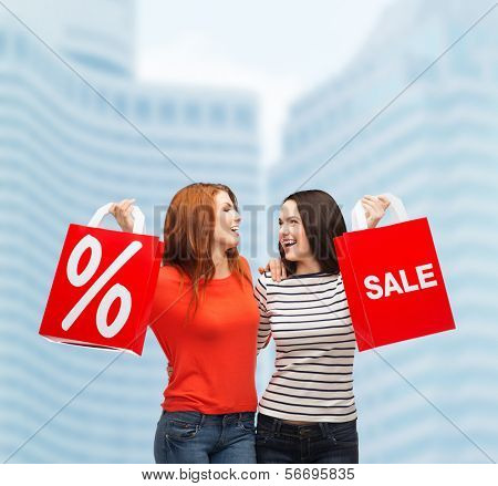 покупки, продажи и дар sconcept - два улыбаясь девочек-подростков с сумки и знак процента