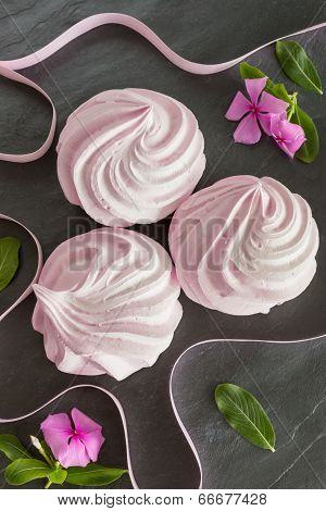 Pink Meringue Or Marshmallow On Gray Background With Perivinkle Flowers