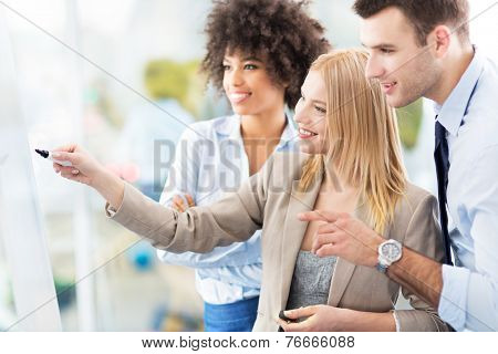Businesspeople looking at flipchart in office 