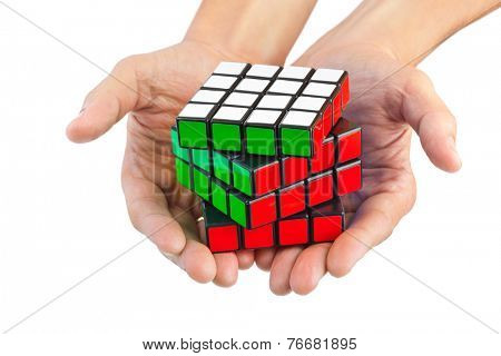 MOSCOW, RUSSIA - August 31, 2014: Hands and Rubik's cube puzzle isolated on the white background. Cube was invented by a Hungarian architect Erno Rubik in 1974.