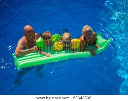 Family Outside Relaxing In Swimming Pool on a lilo