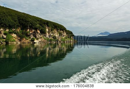 Beautiful coast of the Kurile Lake is reflected in the water.