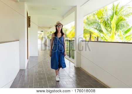 Asian woman walking in corridor of resort 