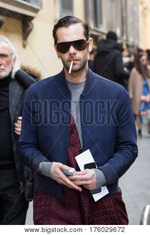 MILAN ITALY - FEBRUARY 25: Fashionable man poses outside Blumarine fashion show during Milan Women's Fashion Week on FEBRUARY 25 2017 in Milan.