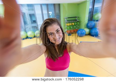 sport woman smile at camera self picture at gym, young girl picture herself exercising fitness center.