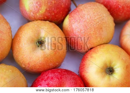 Background with fresh delicious juicy red apples. Delicious colorful sweet-sour apples in the box on the market