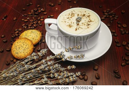 Cup of coffee with milk pussy-willow and dried branches and leaves at white background. Cake on desk