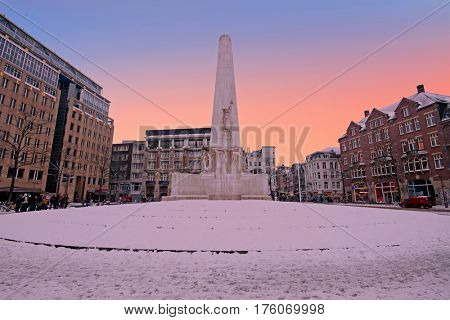 Snowy Damsquare in Amsterdam the Netherlands with the National Monument in winter