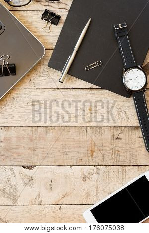 Wooden desk with office equipment laptop and mobile phone with blank screen. top view with copy space