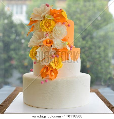 Wedding cake with flowers by the window.