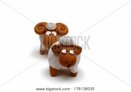 Two white and brown ceramic sheep figurine isolated on white background close up