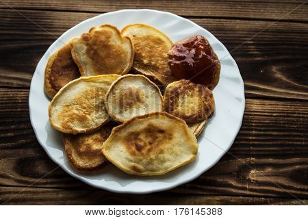 the homemade vegan pancackes with jam wooden background
