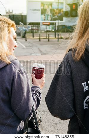 BRISTOL UNITED KINGDOM - MAR 7 2017: Rear view of two girls on Bristol street - one holding Costa coffe-to-go cup