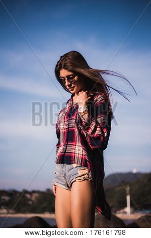 young stylish happy hipster woman traveling around the world wearing aviator sunglasses, denim shirt, tropical island lagoon vacation.