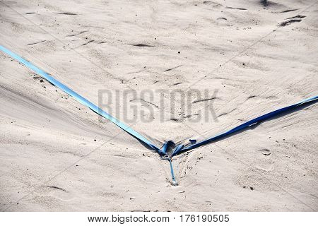 The marking of a beach volleyball field with tension cables in the sand beach.