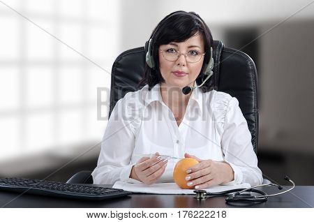 Telecare doctor in headset explains with grapefruit how to give a subcutaneous injection