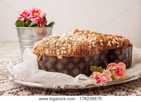 Easter dove on a board with lace tablecloth and a jar with primroses.