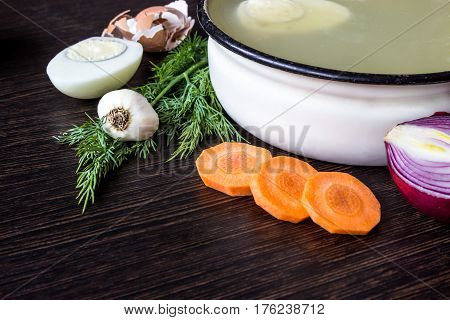 Soup with sorrel vegetables and boiled egg red onion carrots garlic dill on dark wooden table