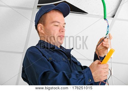 Electrician checking voltage in office