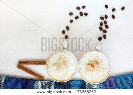 A pair of coffee cups with frothy cappuccino portray a steamer / fantastic coffee cruise for two persons