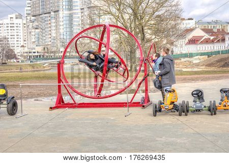 BELORUSSIA MINSK - March 11.2017: The girl is spinning in a crazy attraction on a city street