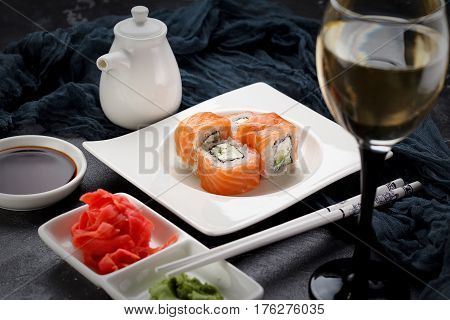 Sushi Roll On A White Plate, Decorated Like In Restaurant Over Dark Concrete Background
