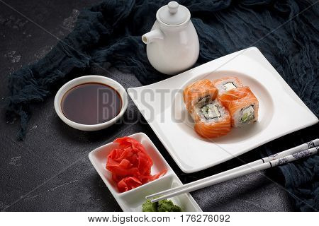 Sushi Roll On A White Plate, Decorated Like In Restaurant Over Dark Concrete Background