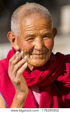 Jelichun India - 27 July, 2012: Friendly looking and smiling old buddhist nun from Jelichun nunnery in a sunny day, close-up portrait