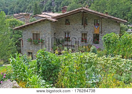Rupit Spain - September 09 2014: Picturesque house of stone with garden in Rupit (Catalonia Spain)