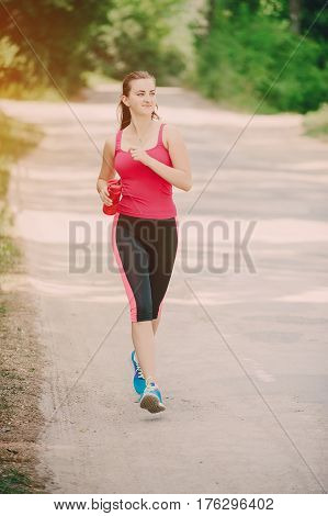 young athletic girl perfoms exercises in the gym running sports and exercieses in the park