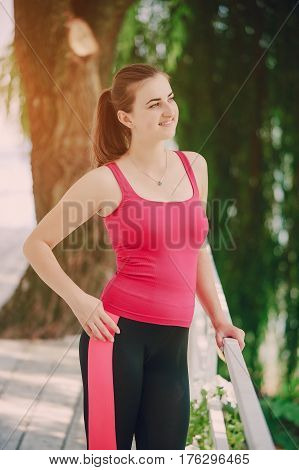 young athletic girl perfoms exercises in the gym running sports and exercieses in the park