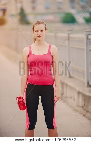 young athletic girl perfoms exercises in the gym running sports and exercieses in the park