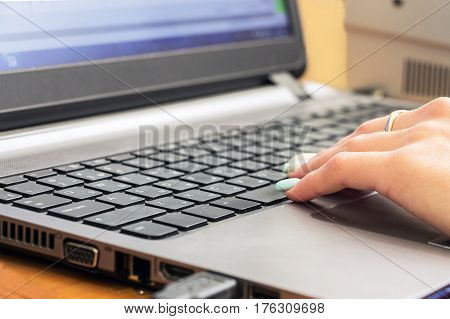 Woman's hand on laptop keyboard. Selective focus