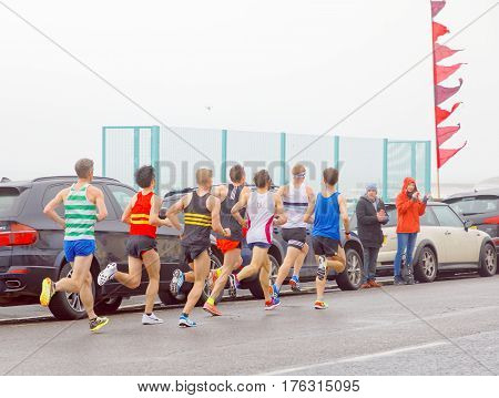 BRIGHTON GREAT BRITAIN - FEB 26 2017: Side view of group of men running in the Vitality Brighton half marathon competition. February 26 2017 in Brighton Great Britain
