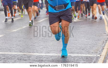 BRIGHTON GREAT BRITAIN - FEB 26 2017: Feet and legs of a running man in lead of a group of runners in the Vitality Brighton half marathon competition. February 26 2017 in Brighton Great Britain