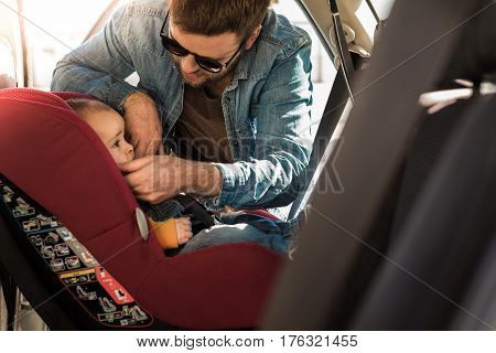 Father Fasten His Baby In Car Seat