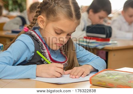First Grader In Class Writing In Notebook