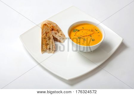 Pumpkin Cream Soup In Bowl With Slices Of Bread