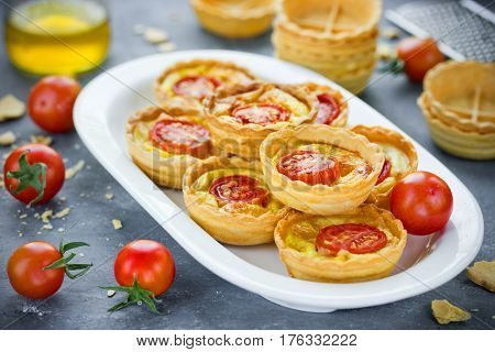 Cheese tomato tartlets puff pastry appetizers mini-pizzas with cheese and cherry tomatoes