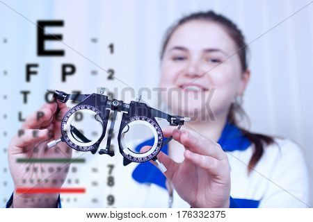 Close-up of optometrist holding messbrille glasses in ophthalmology clinic. Ophthalmic glasses for diopter detection.