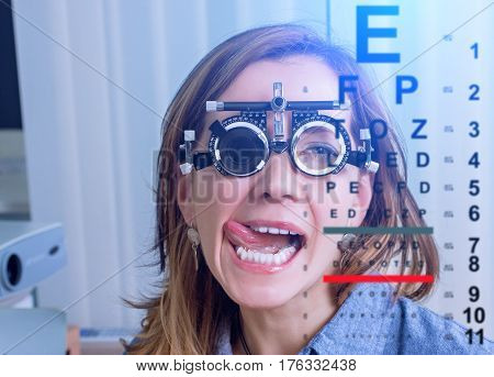 Girl woman in messbrille glasses in ophthalmology clinic. Ophthalmic glasses for diopter detection.