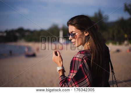 young stylish happy hipster woman traveling around the world wearing aviator sunglasses, denim shirt, tropical island lagoon vacation.