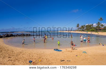 KAUAI, USA - MAR 3: Tourists and locals enjoy Poipu Beach on March 3, 2017 on Kauai, Hawaii. Poipu Beach is one of the most popular tourist areas on the island of Kauai and has many excellent hotels.