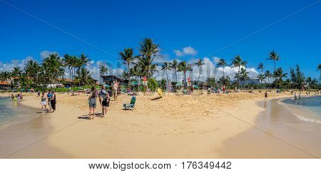 KAUAI, USA - MAR 3: Tourists and locals enjoy Poipu Beach on March 3, 2017 on Kauai, Hawaii. Poipu Beach is one of the most popular tourist areas on the island of Kauai and has many excellent hotels.