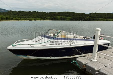 Kamchatka Peninsula, Russia - August 13, 2016: Motor boat of nature protection of Kronotsky Reserve is moored to pier on Kuril Lake. South Kamchatka Nature Park.