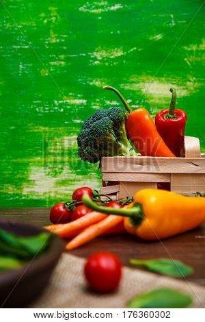 Sweet pepper, brocoli and cherry tomatoes. Brocoli and red radish. Natural raw vegetables. Organic bio food on rustic wooden table.
