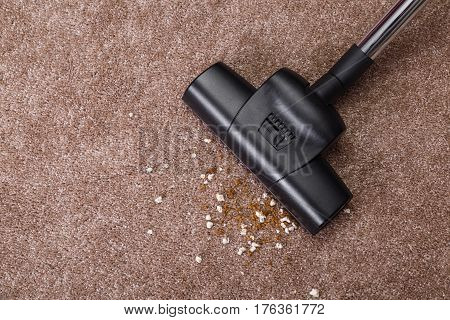 Vacuuming carpet with vacuum cleaner. Dirt on the rug. Housework service. Close up of the head of a sweeper cleaning device.