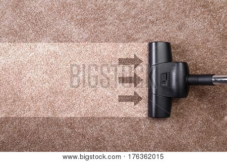 Vacuuming carpet with vacuum cleaner. Housework service. Close up of the head of a sweeper cleaning device.