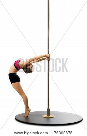 Slim girl in pink bikini streching by the pylon isolated studio shot