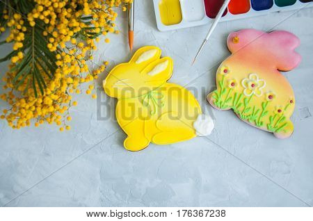 Decorated Easter Bunny Cookies Mimosa Paints And Brushes On A White Background. Easter Concept.